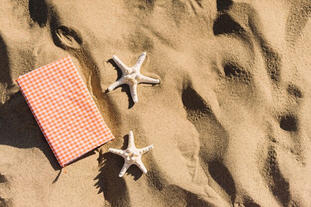 Tagebuch und Seesterne auf dem Sand