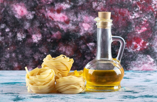 Tagliatelle-Nester und ein Glas Olivenöl.