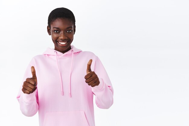 Taillenporträt selbstbewusste afroamerikanische Frau im rosa Hoodie ermutigt Sie, eine Wahl zu treffen, loben Sie Ihre Leistung