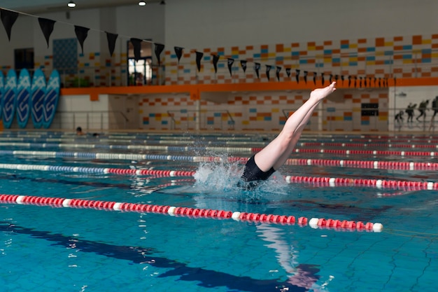 Kostenloses Foto talentierter athlet springt im pool mit vollem schuss