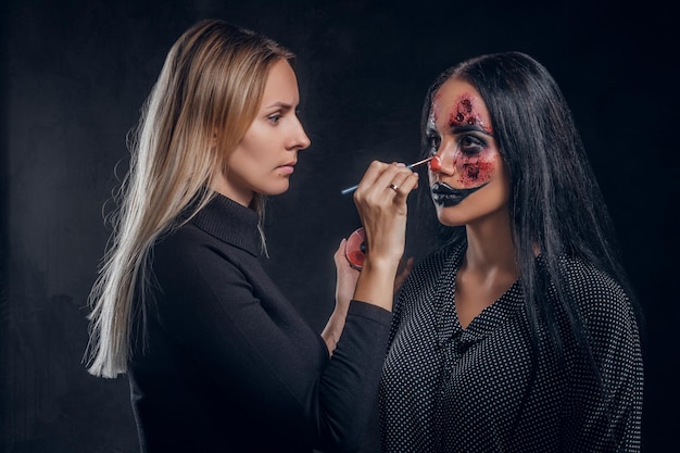 Talentierter Make-up-Künstler kreiert spezielle gruselige Halloween-Kunst auf dem Gesicht der Frau.