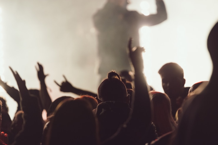 Kostenlose Foto tanzen bei einem konzert, während der sänger inmitten von lichtern auftritt