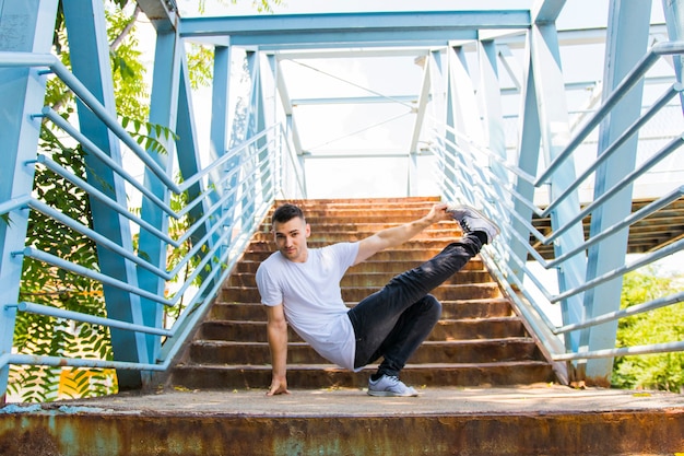 Tanzen des jungen Mannes auf Brücke