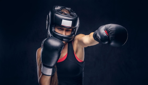 Tapfere Frau ist bereit zu kämpfen, sie trägt Boxerhandschuhe und Schutzhelm.