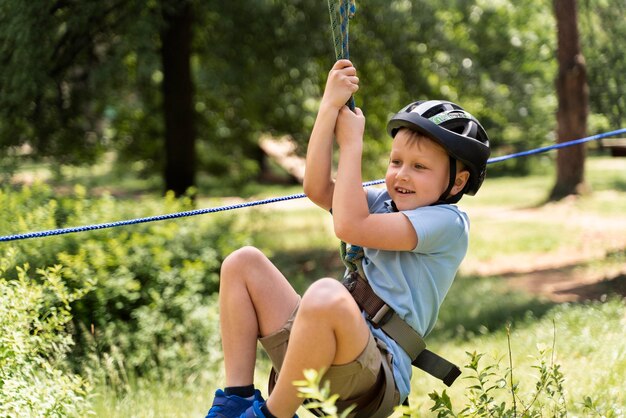 Tapferer Junge, der Spaß in einem Abenteuerpark hat