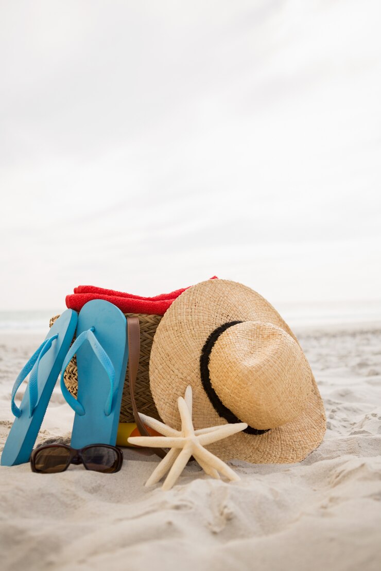 Kostenlose Foto tasche und strand-accessoires auf sand gehalten
