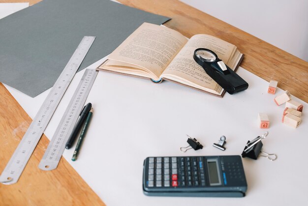 Taschenrechner und Buch in der Nähe von Schreibwaren