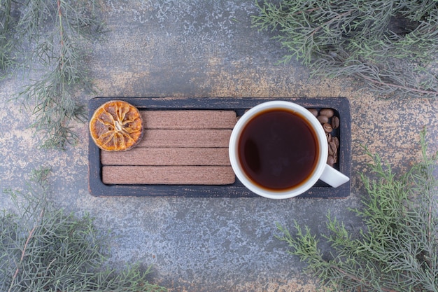 Tasse Espresso, Kekse und Kaffeebohnen auf schwarzem Teller. Foto in hoher Qualität