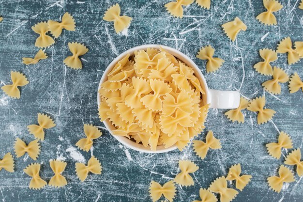 Tasse Farfalle-Nudeln auf blauem Hintergrund. Hochwertiges Foto