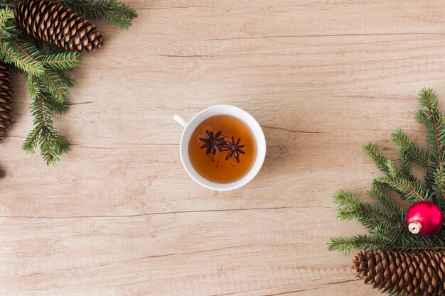 Tasse Getränk zwischen Nadelbäumen und Baumstümpfen