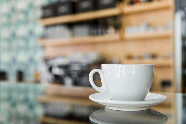 Tasse Kaffee auf reflektierendem Glas