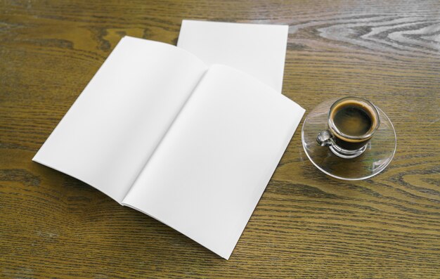 Tasse Kaffee mit Buchstaben neben und einem Notebook