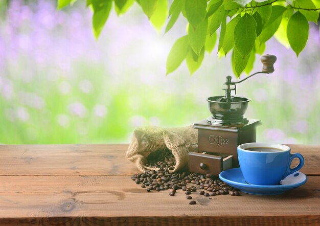 Tasse Kaffee mit einer Kaffeemühle an einem sonnigen Tag