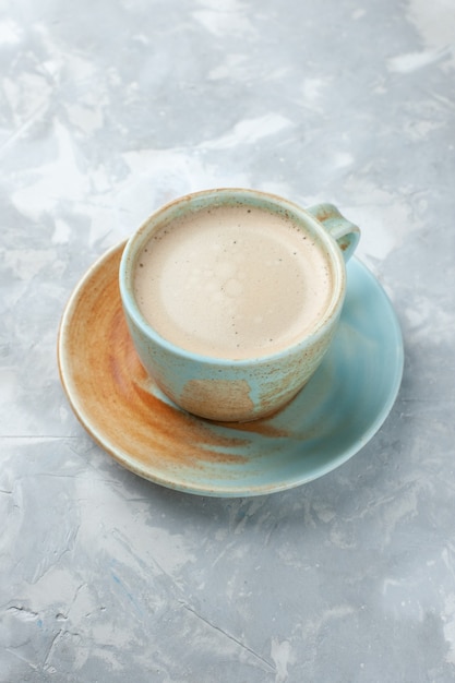 Tasse Kaffee mit halber Draufsicht und Milch in der Tasse auf dem weißen Schreibtisch trinken Kaffeemilch-Schreibtischfarbe