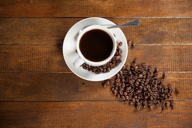 Tasse Kaffee mit Kaffeebohnen und Löffel