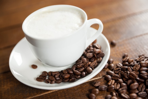 Tasse Kaffee mit Kaffeebohnen und Löffel