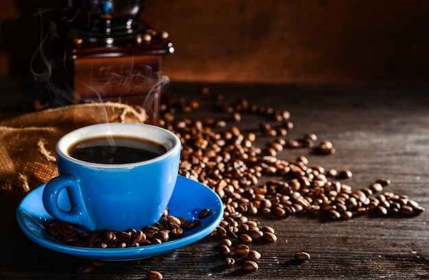 Tasse kaffee mit kaffeebohnen und schleifer hintergrund