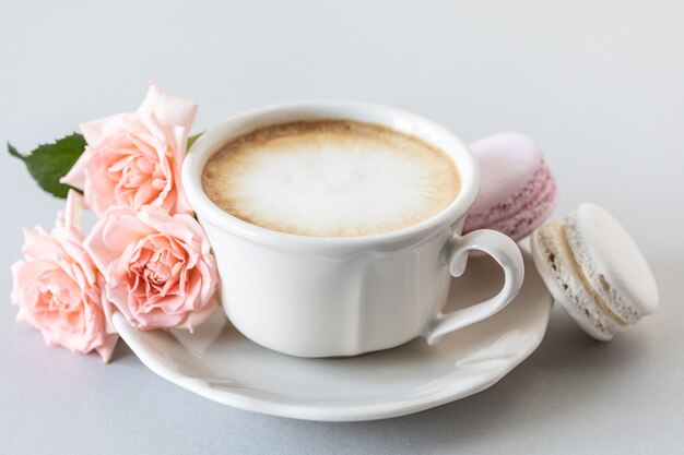Tasse Kaffee, Pasta für den Kuchen und rosa Rosen auf einer grauen Oberfläche. Speicherplatz kopieren.