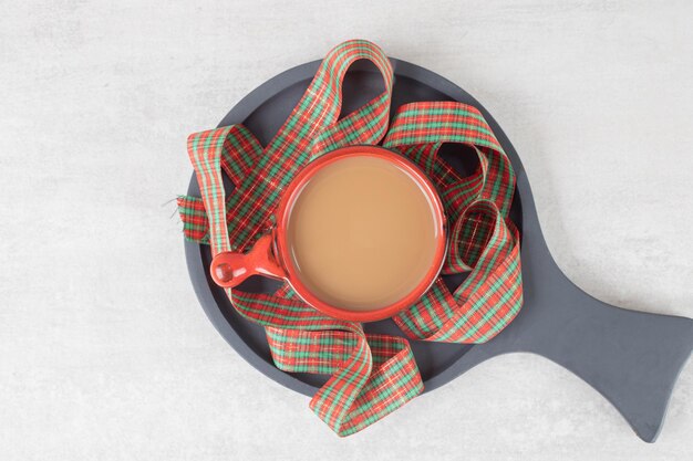 Tasse Kaffee und Band auf dunklem Brett