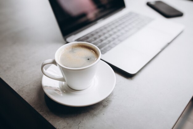 Tasse Kaffee und Computer auf Tisch, Draufsicht