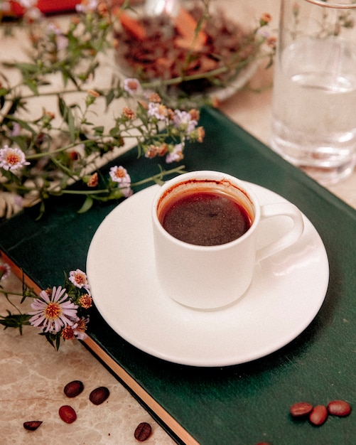 Tasse Kaffee und Kaffeebohnen auf dem Tisch