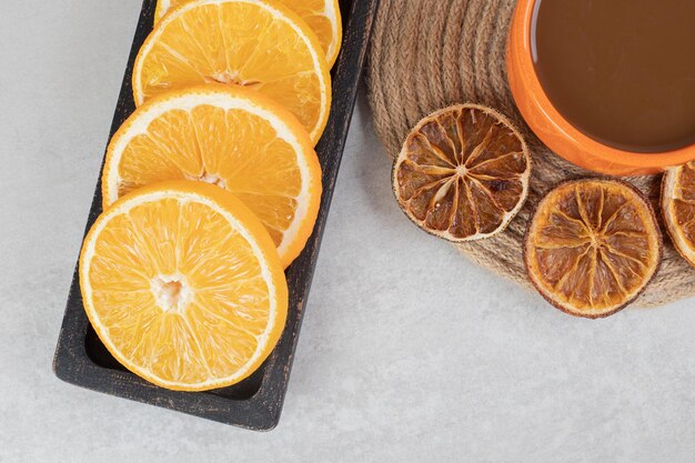 Tasse Kaffee und Teller mit Orangenscheiben