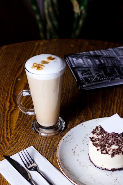 Tasse Latte mit mit Schokolade bestreutem Käsekuchen