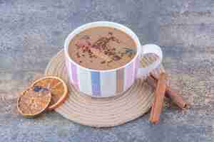 Kostenloses Foto tasse milchkaffee mit zimtstangen und orangenscheiben. foto in hoher qualität