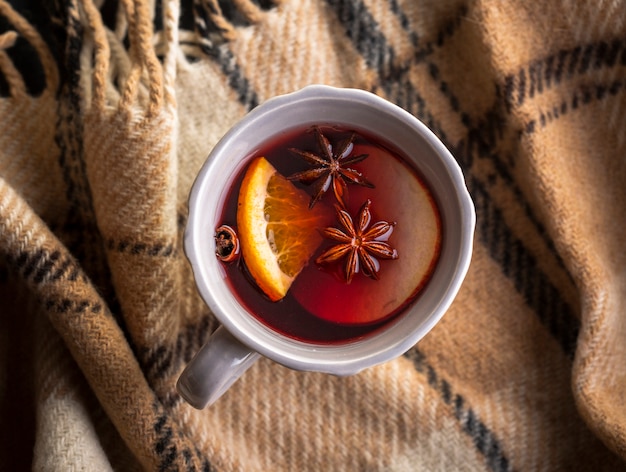 Tasse mit Glühwein und Gewürzen