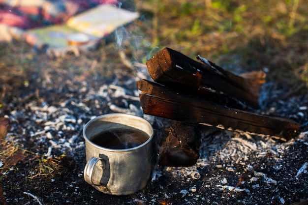 Tasse mit Kaffee neben Feuer löschen