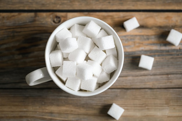 Kostenloses Foto tasse mit zuckerwürfeln auf einer holzoberfläche in nahaufnahme