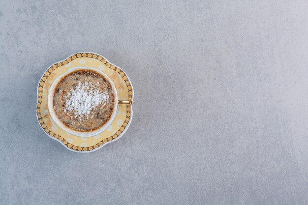 Tasse schaumigen heißen Kaffee auf Steintisch gelegt.