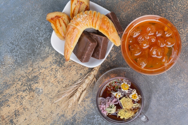 Tasse Tee, Kekse und Beerenmarmelade auf Marmoroberfläche