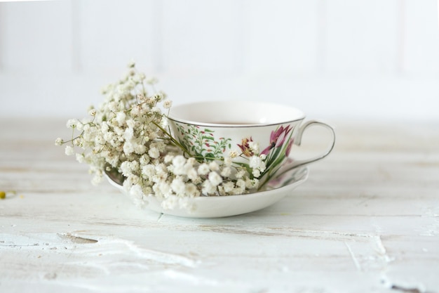 Tasse Tee mit dekorativen Blumen