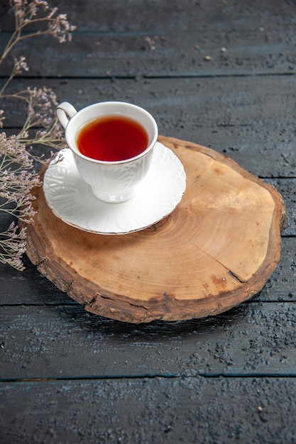 Tasse Tee mit halber Draufsicht auf dunklem Tisch