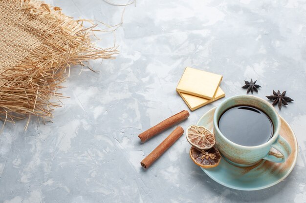 Tasse Tee mit halber Draufsicht mit Bonbons und Zimt auf weißem Schreibtisch Tee Bonbon Farbe Frühstück