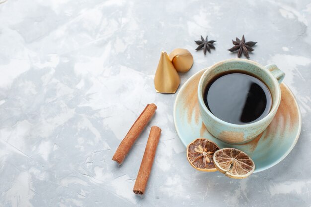 Tasse Tee mit halber Draufsicht und Zimt auf dem weißen Schreibtisch-Tee-Bonbon-Farbfrühstück