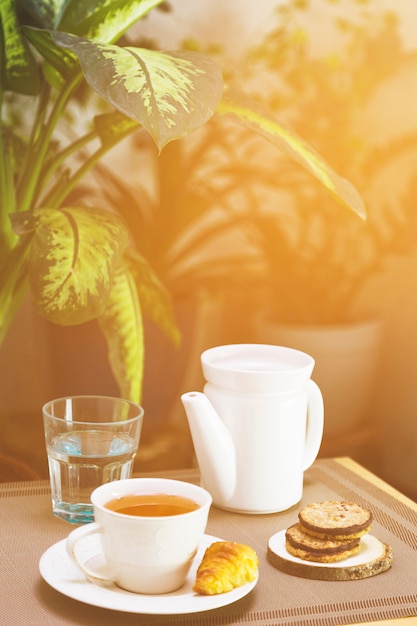 Tasse tee mit teekannen- und frühstückselementen