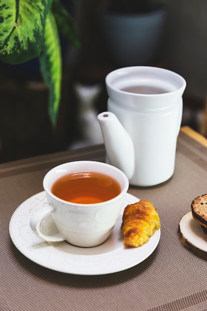 Tasse Tee mit Teekannen- und Frühstückselementen