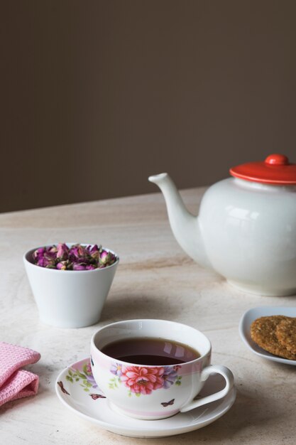 Tasse Tee mit Teekannen- und Frühstückselementen