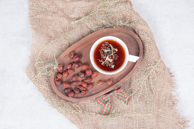 Tasse Tee und getrocknete Preiselbeeren auf Sackleinen. Hochwertiges Foto