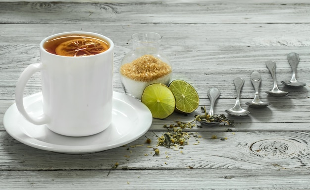 Tasse Tee und Löffel auf einer schönen weißen Holzwand, Winter, Herbst