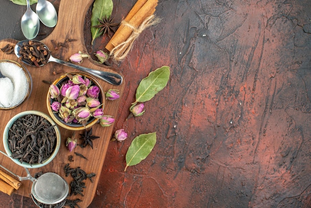 Tasse Tee von oben mit schwarzem Tee und getrockneten Blumen auf dunkelbraunem Hintergrund Tee-Frucht-Aquarell-Frühstückszeremonie-Foto