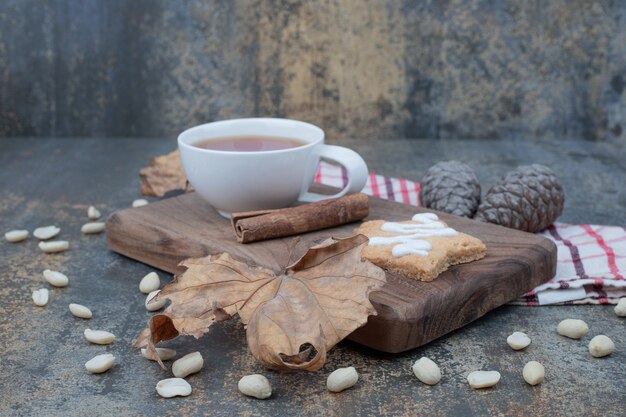 Tasse Tee, Zimt und Lebkuchen auf Holzteller. Hochwertiges Foto