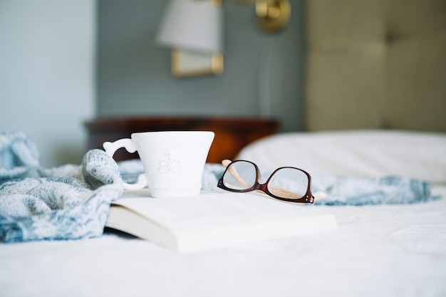 Tasse und Brille auf Buch