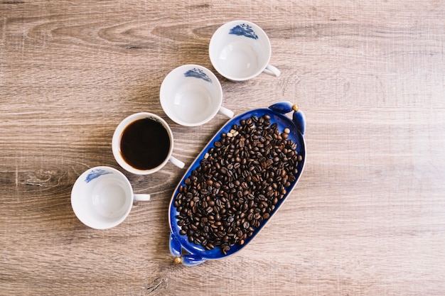 Kostenloses Foto tassen in der nähe von kaffeebohnen