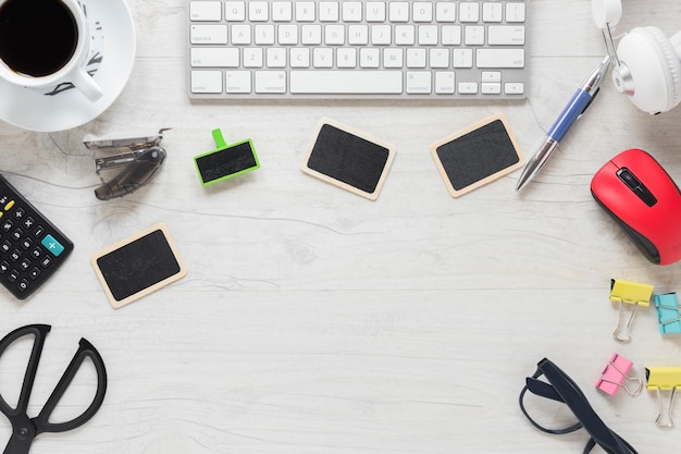 Tastatur; leere Karten; Kaffeetasse und Büromaterial auf dem Schreibtisch