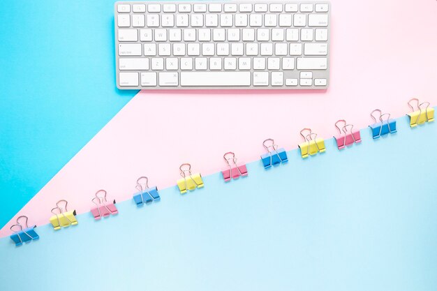 Tastatur und Papier mit bunten Clips auf dem Desktop