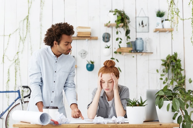 Team junger Designer, die vor der Frist stehen, während sie an einem Architekturprojekt im Büro arbeiten