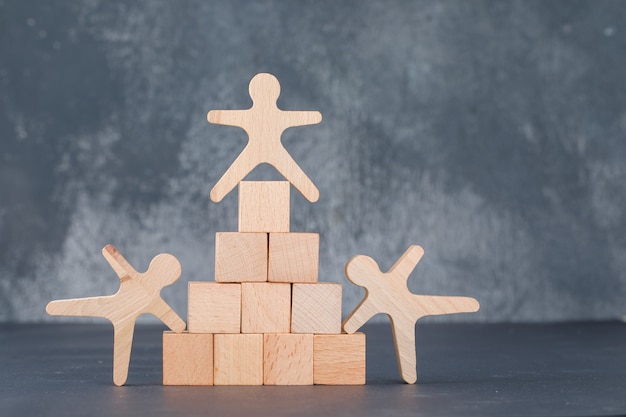 Team- und Geschäftskonzept mit Holzklötzen wie Pyramide mit menschlichen Holzfiguren.